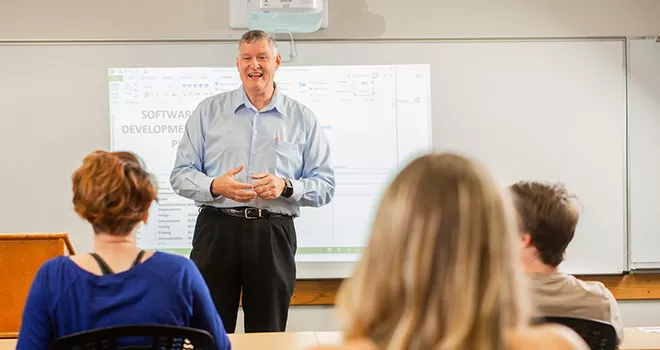 TCC business professor stands in front of a class of students.