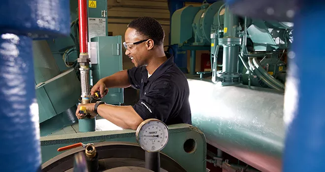 Young man works on tightening a pipe.