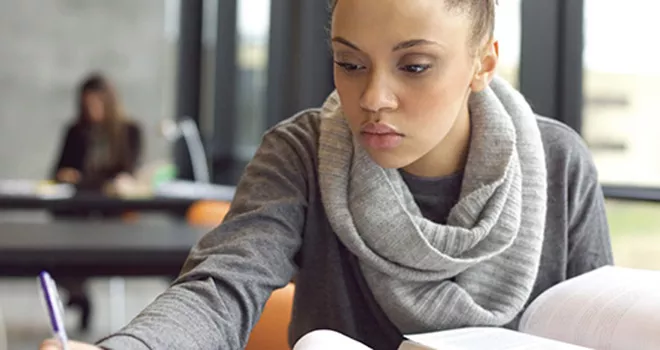 Young female student works diligently at her studies.