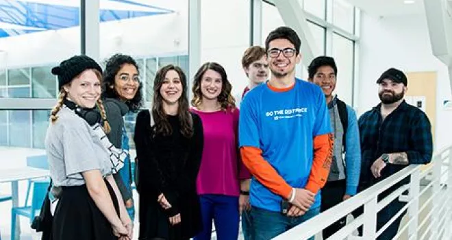 TCC Students pose for group photo on an indoor balcony.